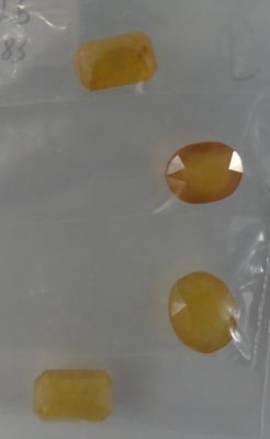 a plastic bag filled with yellow pills on a white surface