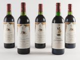 three bottles of red wine are lined up on a white surface