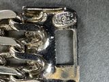 a silver buckle with a horse on it on a table