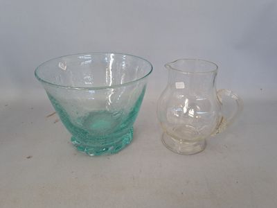 a glass pitcher and a glass bowl sitting on a table