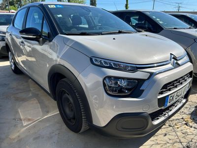une Citroën argentée garée sur un parking à côté d'autres voitures