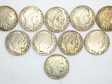 a bunch of silver coins sitting on top of a white surface
