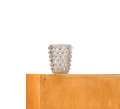 a vase sitting on top of a wooden cabinet