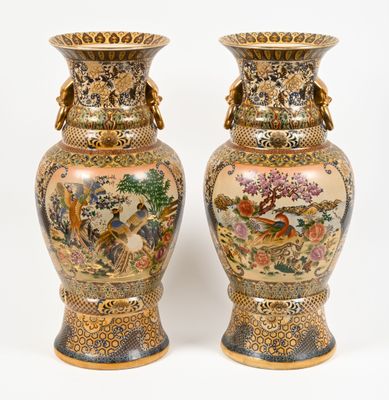 pair of vases with oriental designs on them against a white background