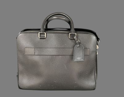 a grey briefcase with a tag on it sitting on top of a table