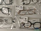 four pairs of eyeglasses are in plastic bags on a table