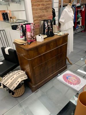 une table en verre sur laquelle se trouve un vase, à côté d'une commode