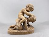 statue en bronze représentant un garçon en train de lutter au sol avec un autre garçon