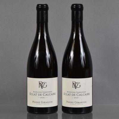 deux bouteilles de vin posées sur une table l'une à côté de l'autre