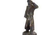 une statue en bronze représentant un homme coiffé d'un chapeau