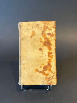 an old book sitting on top of a table next to a black table