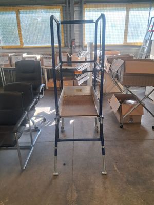 de nombreuses chaises et tables dans une pièce où se trouvent des cartons par terre