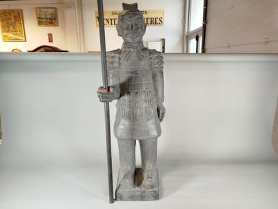 une statue représentant un homme tenant une perche dans une pièce