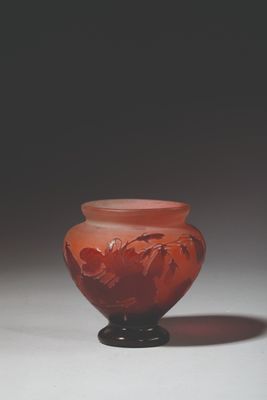 a red vase sitting on top of a white table