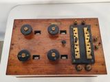 a very old wooden and metal device on a white table