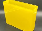yellow plastic planter box with handles on a grey background