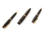 trois stylos sont alignés les uns au-dessus des autres sur une surface blanche