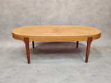 an oval coffee table with two legs and a wooden top
