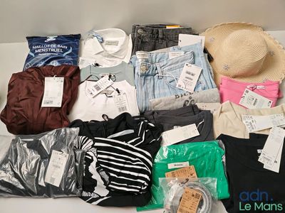 beaucoup de vêtements et un chapeau posés sur une table