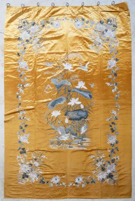 an old chinese embroidered wall hanging with a vase of flowers