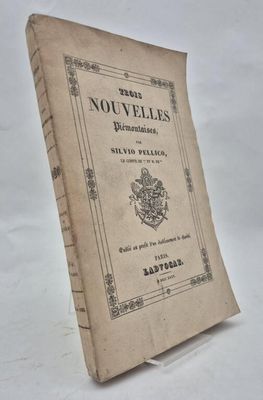 an old book sitting on top of a table on a white surface