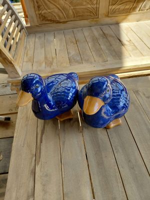 deux oiseaux en céramique bleue posés sur une table en bois