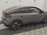 the rear end of a gray car parked in a garage