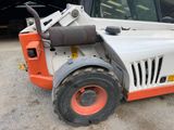 a small orange and white forklift parked in a parking lot
