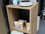 a small shelf with a coffee maker on top of it