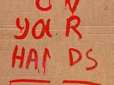 a cardboard sign on the side of a building that says blow your hands