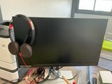a computer monitor with headphones on top of it