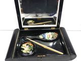 a black box with a bowl of food and chopsticks in it