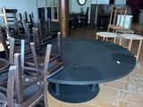 many chairs and tables in a room with a clock on the wall