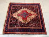 un tapis posé au sol, orné d'un motif rouge et bleu