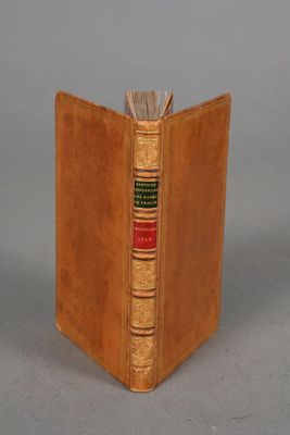 an old book with a leather cover sitting on top of a table