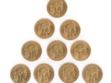 six british gold sovereigns arranged in a pyramid on a white surface