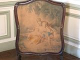 une photo d'une chaise dans une pièce où se trouve un tableau accroché au mur