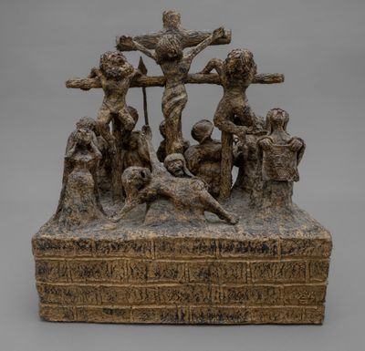 une statue en bronze représentant Jésus sur la croix, entouré d'un groupe de personnes