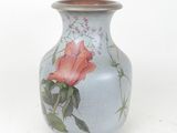 a vase with a rose painted on it on a white background