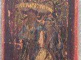 un vieux tableau représentant une femme tenant un éventail, accroché au mur