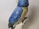 a figurine of a parrot sitting on a branch