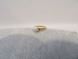 a gold ring with a pearl on top of a rock
