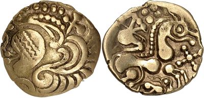 a close up of two gold coins with designs on them
