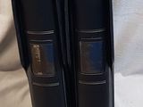 trois livres noirs sont empilés les uns sur les autres sur une surface blanche