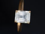 a close up of a gold ring with a white stone