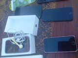 Plusieurs téléphones portables sont posés sur une table, à côté d'une boîte d'écouteurs.