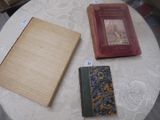 trois livres posés sur une table recouverte d'une nappe blanche