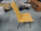 a yellow chair sitting in a room with other furniture