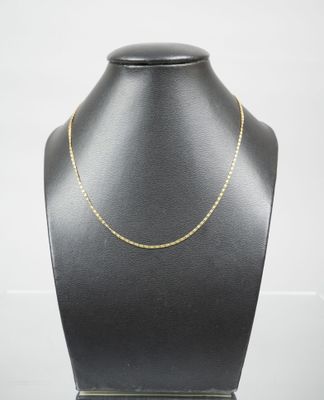 a gold chain necklace on a mannequin display