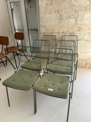 plusieurs chaises et une table dans une pièce, avec un mur en arrière-plan